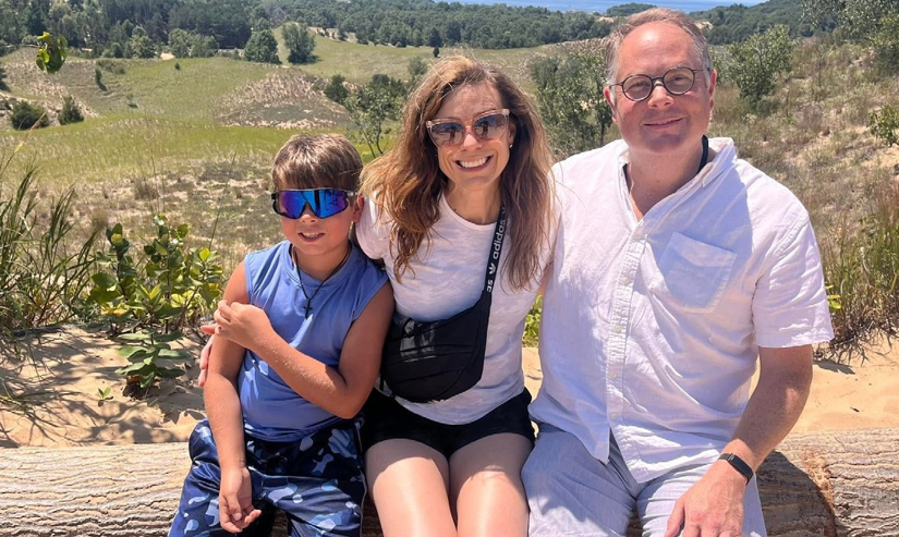 A man in a white shirt next to a woman and child.
