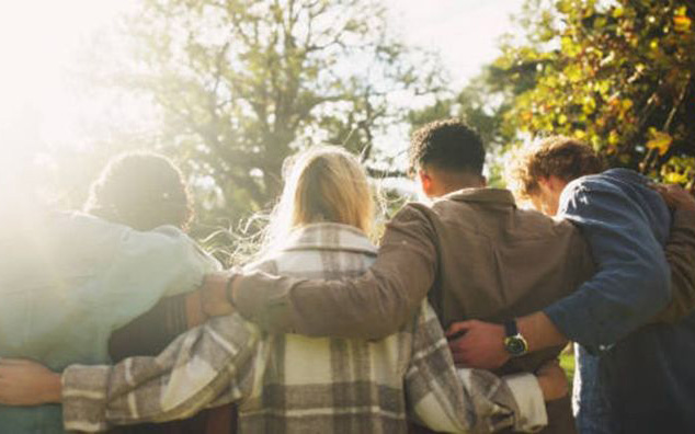 Teens with their arms around each other.